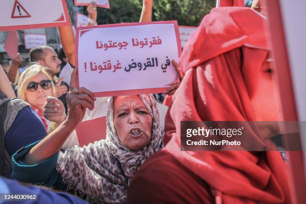 An elderly woman hold a sign that reads in Arabic, you have impoverished us, starved us, drowned us in debts, during a protest march held by the Free...