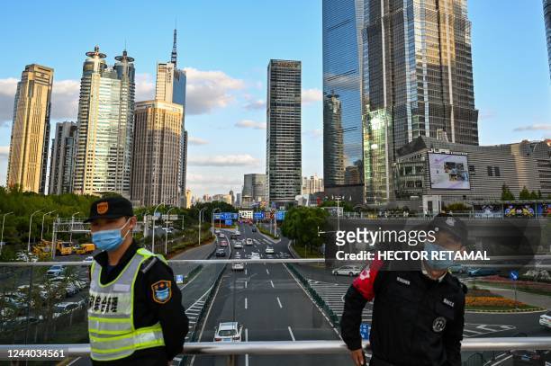 Guards stand on a bridge in the financial district of Lujiazui in Shanghai on October 17, 2022.