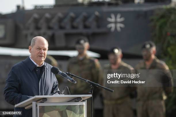 German Chancellor Olaf Scholz speaks with soldiers of the Bundeswehr while visiting the Bundeswehr army training center in Ostenholz on October 17,...