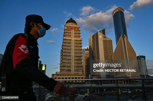 Guard walks on a bridge in the financial district of Lujiazui in Shanghai on October 17, 2022.