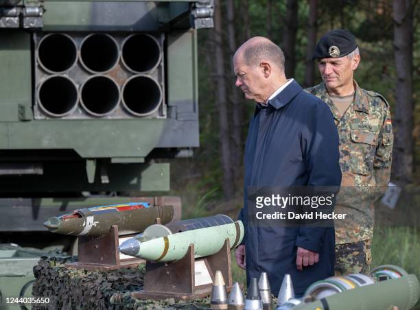 Chancellor Olaf Scholz looks at munition during a visit at the Bundeswehr army training center in Ostenholz on October 17, 2022 near Hodenhagen,...