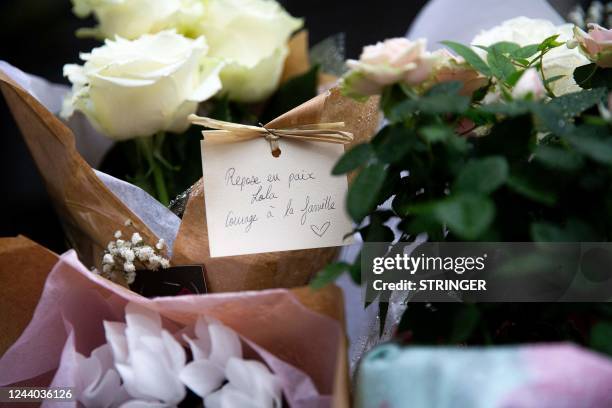 Photograph shows bunches of flowers with a hand-written message which reads as "Rest in peace Lola, courage for the family", displayed outside the...