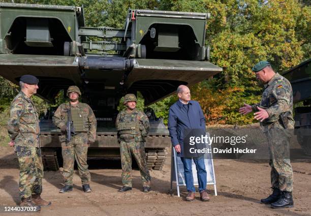 Brigadier general Andreas Kuehne explaines Chancellor Olaf Scholz the bridge building tank Biber during a visit at the Bundeswehr army training...