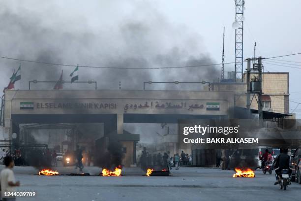 Demonstrators burn tires as they gather in the Syrian opposition-held crossing of Bab al-Salama, at the border with Turkey in the northern Aleppo...