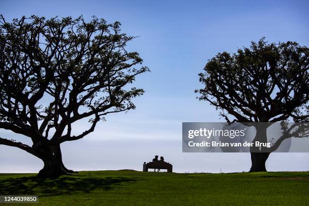 October 16, 2022 - A couple enjoy balmy weather along with an ocean view from a bench on the lawn at Alumni Park at Pepperdine University in Sunday,...