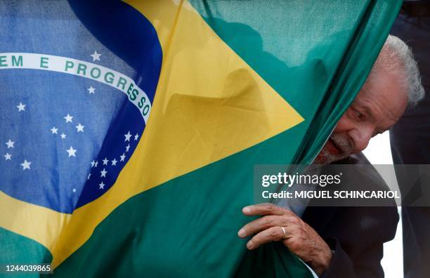 Brazilian former president and presidential candidate for the leftist Workers Party , Luiz Inacio Lula da Silva, appears behind a Brazilian national...