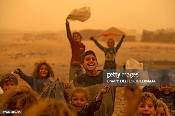 Children play amid a sandstorm at the Sahlat al-Banat camp for displaced people in the countryside of Raqa in northern Syria on October 17, 2022.