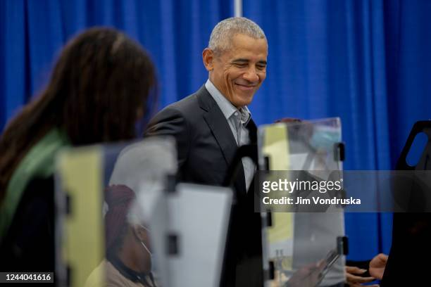 Former first lady Michelle Obama and former U.S. President Barack Obama sign in to casts their vote at an early voting venue on October 17, 2022 in...
