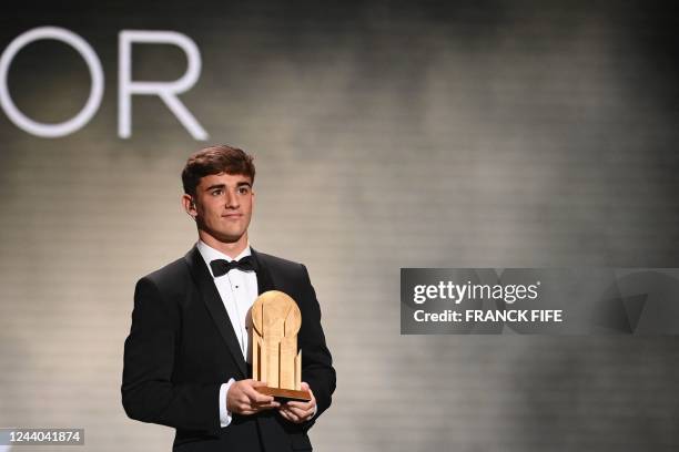 Barcelona's Spanish midfielder Gavi poses with the Kopa Trophy for best under-21 player during the 2022 Ballon d'Or France Football award ceremony at...