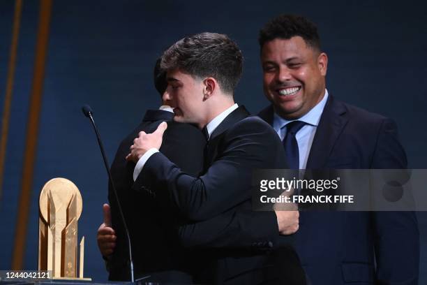 Barcelona's Spanish midfielder Gavi receives the Kopa Trophy for best under-21 player from Brazilian former football forward Ronaldo and FC...