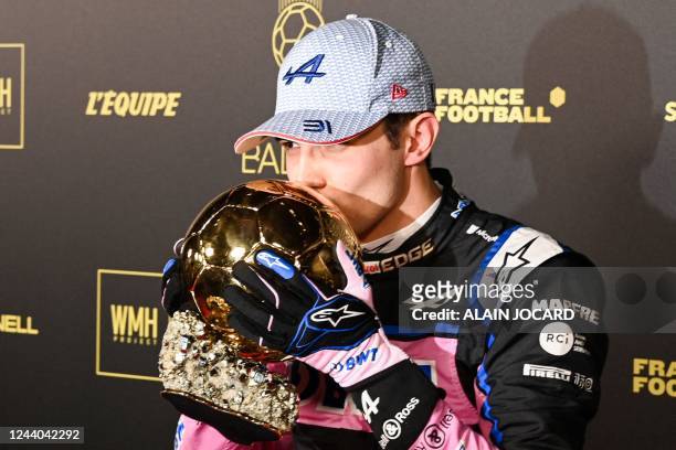 Alpine's French driver Esteban Ocon poses with the Ballon d'Or trophy upon arrival to attend the 2022 Ballon d'Or France Football award ceremony at...