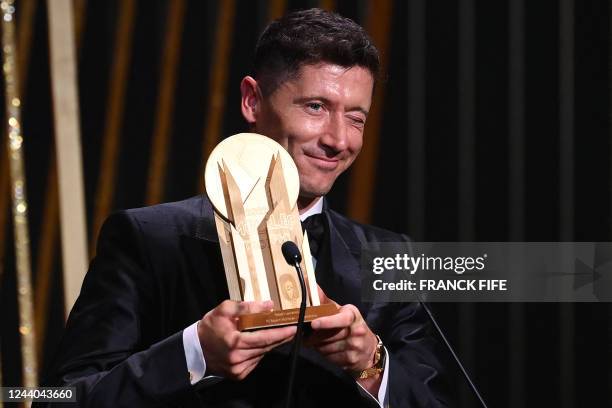 Barcelona's Polish forward Robert Lewandowski receives for the second time the Gerd Muller Trophy for best striker during the 2022 Ballon d'Or France...