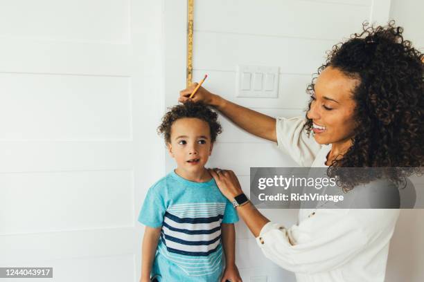 mãe medindo altura do filho - instrumento de medição - fotografias e filmes do acervo