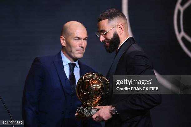 Real Madrid's French forward Karim Benzema receives the Ballon d'Or award from French former forward football player Zinedine Zidane during the 2022...
