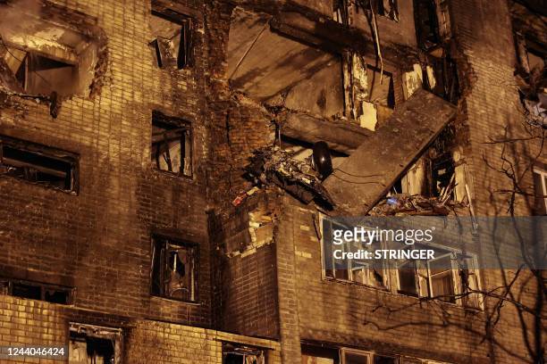 The chassis of a Sukhoi Su-34 military jet sticks out of a partially destroyed nine-storey apartment building after it crashed in the courtyard of a...