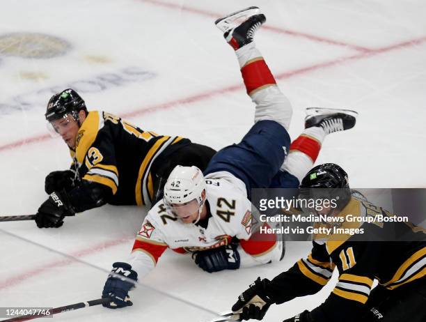 October 17: Gustav Forsling of the Florida Panthers falls in-between Charlie Coyle and Trent Frederic of the Boston Bruins during the second period...