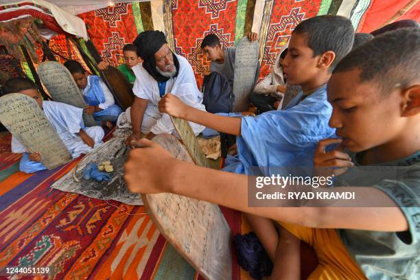 Sahrawi children attend a class to read, write and recite the Koran using wooden plates, at a camp for refugees from Awsard, in Tindouf, where the...