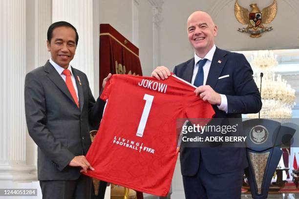 Gianni Infantino , president of football's world governing body FIFA, presents a souvenir jersey to Indonesias President Joko Widodo during a joint...