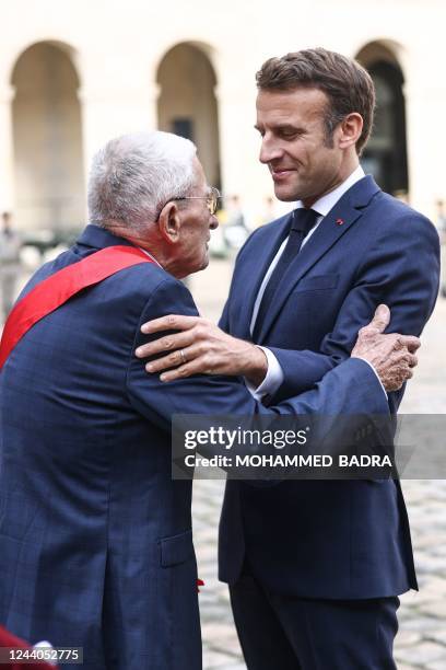 French President Emmanuel Macron awards a medal to a veteran who fought in Algeria during a tribute ceremony to veterans of the Algerian War, at the...