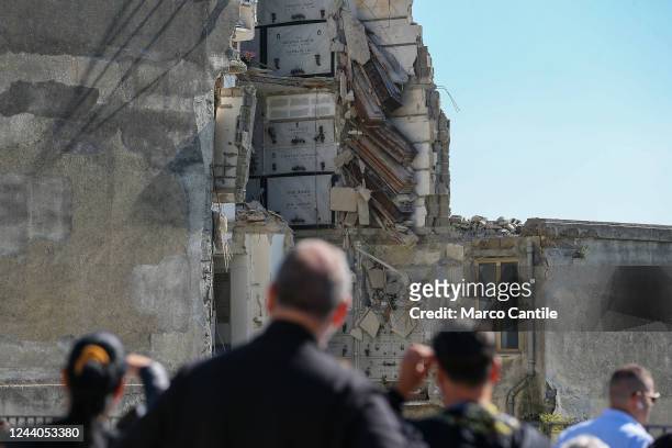 People look at the partially collapsed building inside the Poggioreale cemetery in Naples, with the coffins suspended in the void. The cemetery was...
