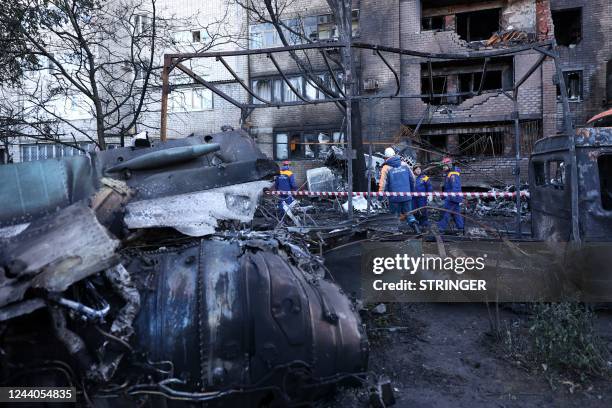 Russian Emergencies personnel remove the wreckage of a Sukhoi Su-34 military jet off its crash site in the courtyard of a residential area in the...