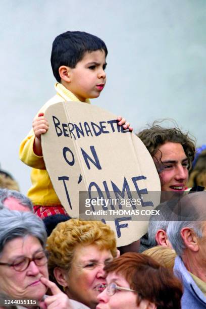 Un jeune garçon tient une pancarte avec l'inscription "Bernadette on t'aime", le 14 avril 2001, devant la mairie de Meulan, où le président de la...