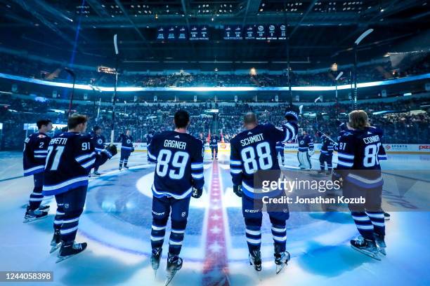 Members of the Winnipeg Jets salute the fans following the player introductions prior to their home opener against the New York Rangers at Canada...