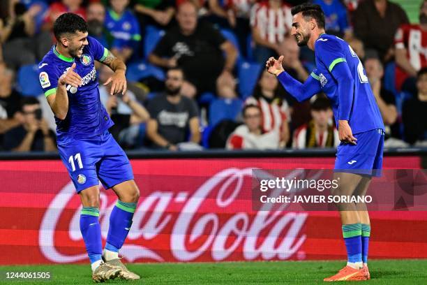 Getafe's Spanish midfielder Carles Alena celebrates with Getafe's Spanish defender Juan Iglesias after scoring his team's first goal during the...