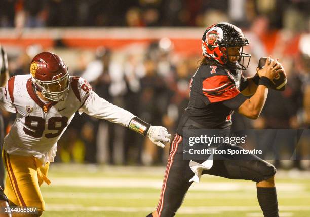 Utah Utes quarterback Cameron Rising runs from USC Trojans defensive lineman Nick Figueroa during a game between the USC Trojans and the University...