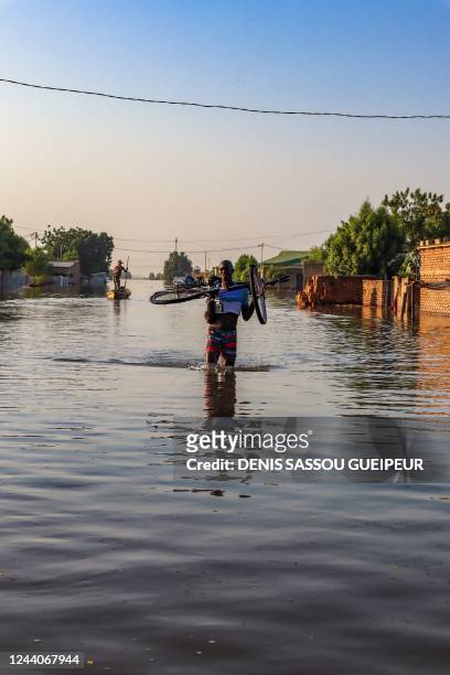 Man wades through a flooded street in N'Djamena on October 18, 2022. - Flooding has destroyed dozens of houses in Walia, a poor neighbourhood in the...