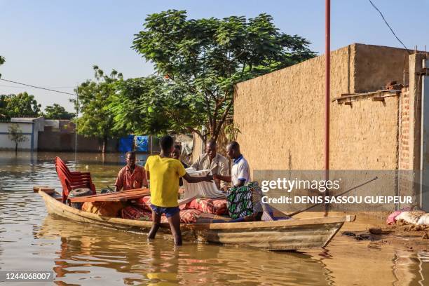 Residents try to salvage items from houses submerged by floods in N'Djamena on October 18, 2022. - Flooding has destroyed dozens of houses in Walia,...