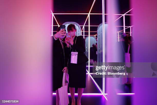 Attendees use smartphones to take selfie photographs inside a photo spot for Instagram in the Meta Platforms Inc. Booth at Metaverse Expo Japan at...