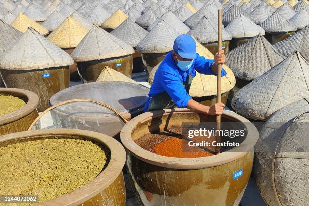Photo shows workers stirred the soy sauce in a VAT in Rugao City, East China's Jiangsu Province, Oct 19, 2022. "Rugao Old soy sauce" brewed with...