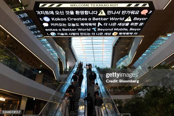 Kakao Corp. Employees ride escalators at the lobby of the company's office building in the Pangyo district of Seongnam, South Korea, on Wednesday,...