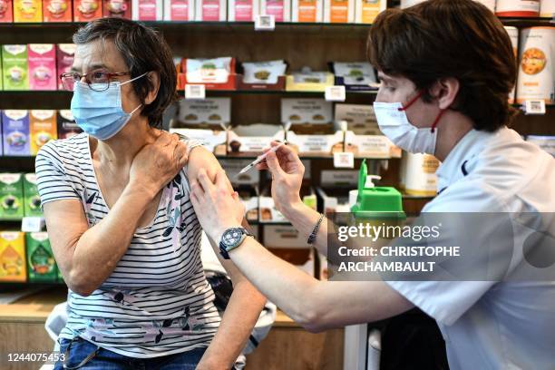 Woman receives a Covid-19 vaccine shot at a pharmacy in Paris on October 19, 2022.