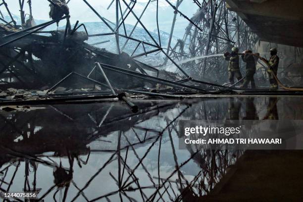 Firefighters spray water on the smouldering remains of the collapsed dome of the Islamic Centre mosque, which caught fire during ongoing renovation...