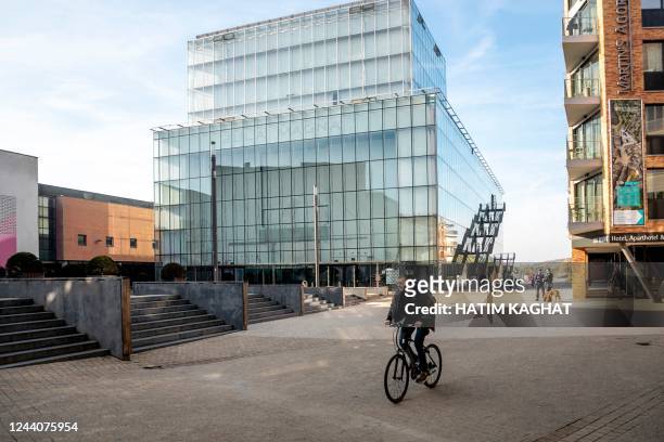 Man rides a bicycle in front of the Aula Magna building of the UCLouvain university in Louvain-la-Neuve, on October 19, 2022. - Belgium OUT / Belgium...