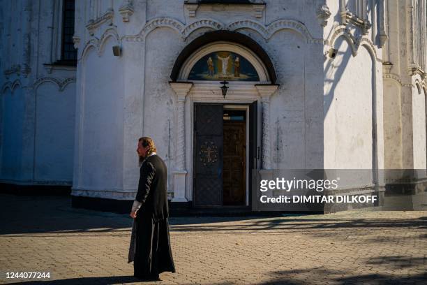 This photograph taken on October 18 shows Orthodox priest Semion walking in the yard of Svyato-Preobrazhens?kyy church in the town of Izyum, amid...