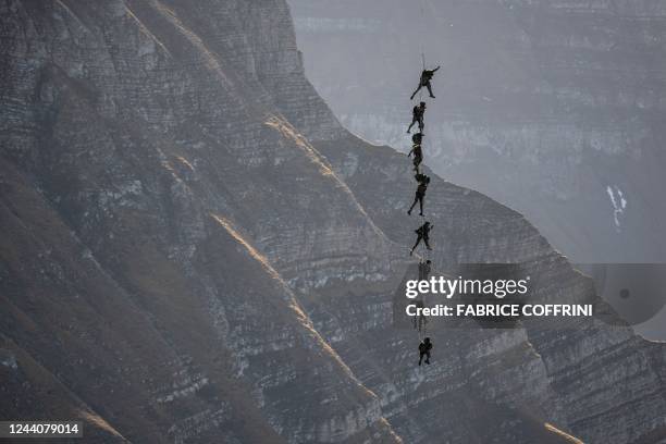 Soldiers of the Swiss special forces command perfom, suspended from an helicopter, during the annual live fire event over the Axalp in the Bernese...