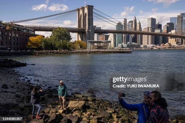 People take photos near Brooklyn Bridge Park in New York City on October 19, 2022.