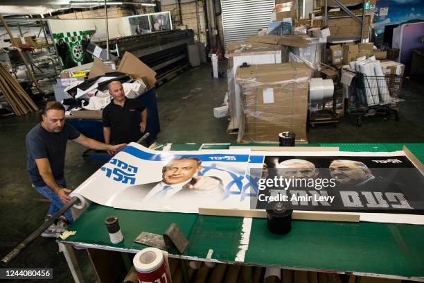 Print house workers roll up a Likud party election campaign posters that show former Israeli Prime Minister and Likud Party leader Benjamin...