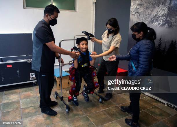 David Zabala, an 8-year-old boy with cerebral palsy, is assisted by physical therapists and his mother, Guadalupe Cardozo Ruiz , during a...