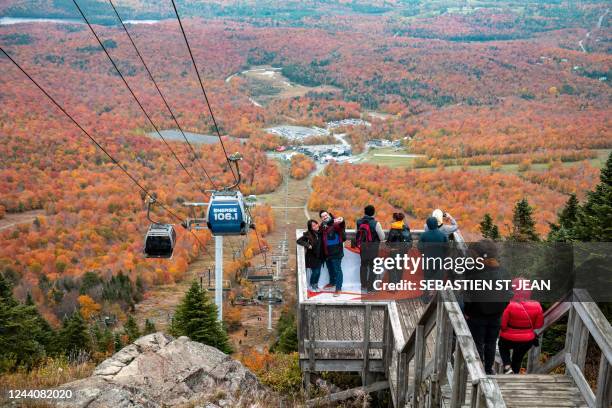 Visitors take pictures as others ride the ski-lift to Mont-Orford in the Mont-Orford National Park near Orford, Quebec, Canada, on October 8, 2022.