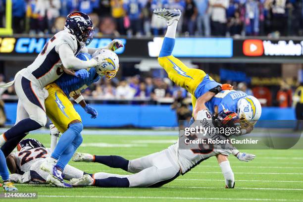 Inglewood, CA, Monday, October 17, 2022 - Los Angeles Chargers running back Austin Ekeler is knocked airborne on a run during overtime against Denver...