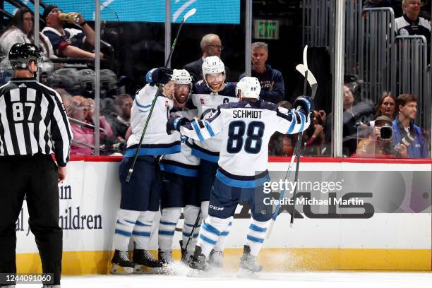 Neal Pionk, Sam Gagner, Adam Lowry, and Nate Schmidt of the Winnipeg Jets celebrate a goal against the Colorado Avalanche at Ball Arena on October...