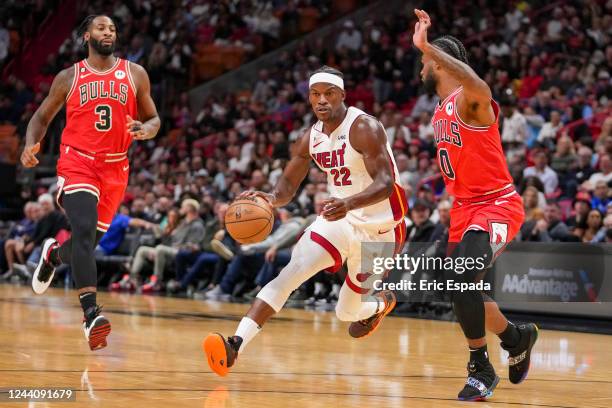 Jimmy Butler of the Miami Heat drives against Coby White of the Chicago Bulls during the second quarter at FTX Arena on October 19, 2022 in Miami,...