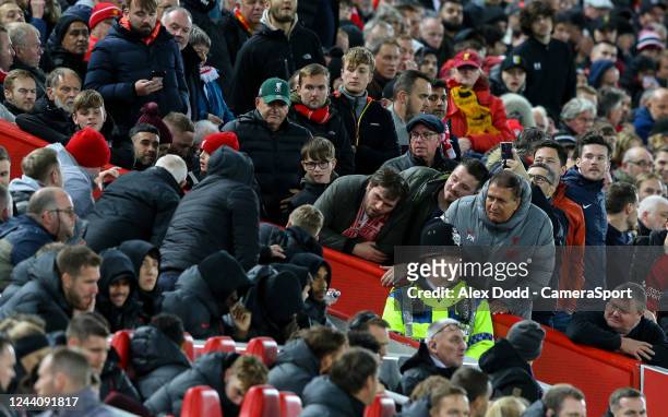 Liverpool fans try to see the screen as referee Stuart Attwell reviews a foul during the Premier League match between Liverpool FC and West Ham...