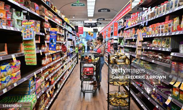 Woman shops for groceries at a supermarket in Monterey Park, California on October 19, 2022. - Food prices in September rose 13% over last year,...