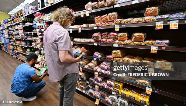 People shop for bread at a supermarket in Monterey Park, California on October 19, 2022. - Food prices in September rose 13% over last year,...