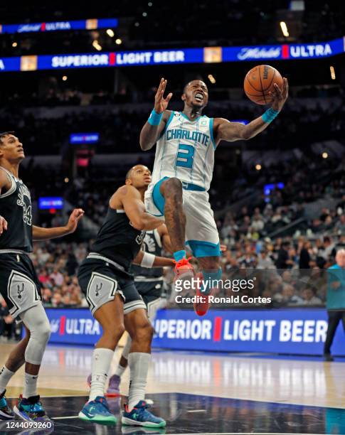 Terry Rozier of the Charlotte Hornets scores past Keldon Johnson of the San Antonio Spurs in the first half at AT&T Center on October 19, 2022 in San...